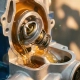 Precision automotive thermostat with metallic surfaces inside engine block cutaway, coolant flowing through channels with golden workshop lighting