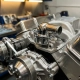 Chrome thermostat housing centered in pristine car engine block with polished metal surfaces and precision-machined components