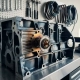 Engine block with central thermostat component showing heat stress patterns from blue-gray to amber tones in automotive workshop