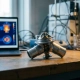 Automotive thermostat wax-element housing on a lab bench beside a laptop displaying thermal simulation heatmaps, lit by soft directional light.