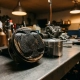 Carbon-clogged engine piston head coated in thick black deposits beside a clean comparison piston on a steel workshop surface.