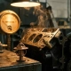 Precision car thermostat beside a disassembled engine block with heat shimmer, copper and charcoal tones in soft workshop lighting.
