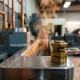 Brass wax pellet thermostat element on machined metal surface above engine coolant channel with heat shimmer visible.