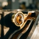 Cutaway thermostat valve exposing a waxy wax element inside a brass housing with coolant channels in an engine block.