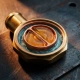 Cross-sectioned wax thermostat element revealing internal wax core inside a polished brass valve housing with coolant channels visible.